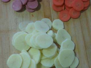 2、自制麻辣香锅,火腿 土豆 胡萝卜处理后切片  蒜切末如图备好待用；