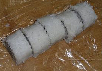 5、黄袍加身寿司,卷好打开保鲜膜去两头再切成小段