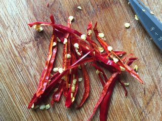 2、水煮肉片,干红辣椒用水浸泡软后擦干水分用剪刀剪成丝;