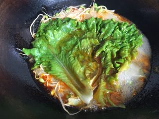 8、水煮肉片,放入生菜叶焯一会儿,不要过头;