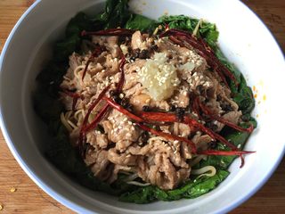 11、水煮肉片,捞出肉片放到菜里,放入之前煸炒过的辣椒丝、花椒,肉片最顶上放蒜泥,撒一些白芝麻;