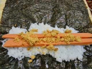 4、寿司小卷,海苔铺在寿司帘上，铺上米饭，放入火腿，肉松。