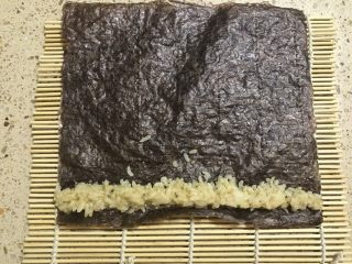 2、小熊寿司,取一片紫菜，上面放上一小部分酱油米饭。