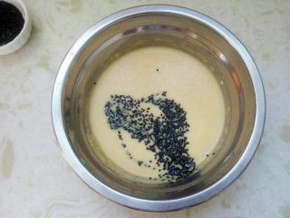 8、黑芝麻蛋卷，十分钟搞定早餐,把适量的芝麻洒在鸡蛋面糊上。