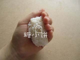 3、章鱼片握寿司,取一小团米饭放在手心中.