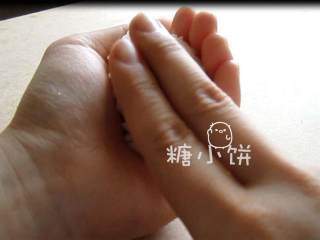 4、章鱼片握寿司,用另一只手的食指和中指按压表面，同时捏紧饭团。完成饭团坯.