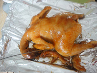 11、奥尔良烤鸡,把鸡移到铺上锡纸的烤网上，用针戳几个洞，这样烤的时候能把多余的汁水流出