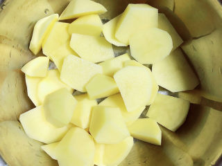 4、红烧土豆鸡块,土豆滚刀切块儿放入盆中。