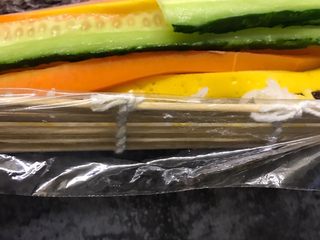 15、肉松寿司,把保鲜膜的一边包在寿司帘的下方