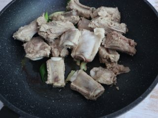 5、酱香排骨焖饭,放入排骨段翻炒。