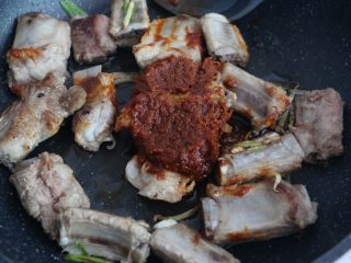 6、酱香排骨焖饭,排骨微微焦黄时，加入两大勺香菇酱。