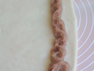 10、香芋红豆驴打滚,在糯米皮的一端，挤上一条芋头馅。