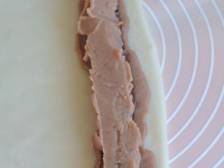 12、香芋红豆驴打滚,最上面，再挤一条芋头馅，用勺背抹平。