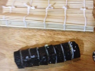 12、三文鱼寿司,把卷好的三文鱼寿司用刀切开。