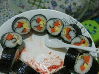 8、紫菜包饭,用刀切成小段就可以吃了，嘿嘿我已经开始吃了。