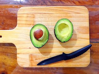 2、吃豆腐+健康饮食之好吃到飞起的牛油果拌豆腐,然后用手分别捏着牛油果的两边，一扭，就打开了！