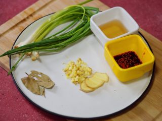 1、香辣秋葵手撕鸡,准备配料：葱、姜、香叶，料酒，红油辣子。葱一把捆成结用来后面煮鸡肉，剩下切成葱末。生姜一部分切成姜末，一部分切成姜片。