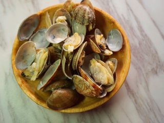 4、花甲丝瓜汤,将花甲放入沸水中烧开待壳全部张开后捞出,放入清水中反复冲洗,尽量将沙子全部冲出来