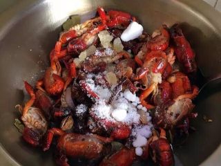 17、啤酒麻辣小龙虾,整体炸出香味后放进处理好的小龙虾进去翻炒。待龙虾全部炒变色，并且尾部向里卷起，将白糖、冰糖一起倒进去翻炒均匀。