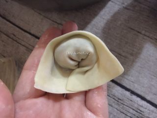 11、葱油拌馄饨,接着对折，再把下方两角相叠粘住，成元宝状
