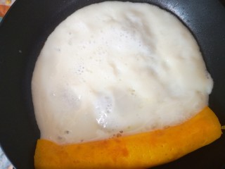 9、双色厚蛋烧,将卷起来的蛋卷朝自己方向拉过来后再倒入少许蛋白液