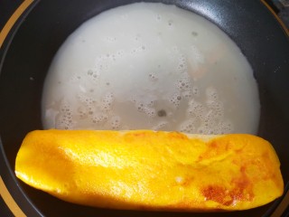 12、双色厚蛋烧,再倒入蛋白液，基本凝固后卷起来，然后再拉过来