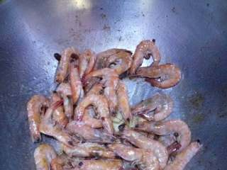 3、虾(蟹)肉煲,热锅冷油下生姜片,加一匙豆板醬,炒出香味入虾,炒至变色下料酒年糕