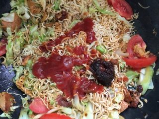 12、沙茶酱炒面#面条变身计划#,放入一大勺的沙茶酱和番茄酱翻炒均匀，放适量的鸡精。