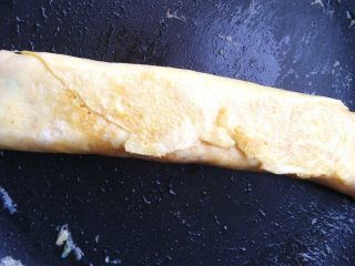 6、紫菜蛋包饭,翻过来看，底部已经凝固粘合好了，继续转动鸡蛋卷，让各部分受热均匀