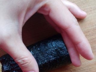 9、紫菜蛋包饭,左手拇指按住鸡蛋卷，食指和中指稍抵住内馅，右手用锋利的刀子将其切块