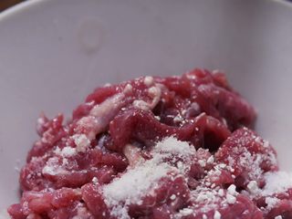 3、江西炒粉,100克洗净的牛肉切丁,用少许红薯粉和适量盐抓匀;