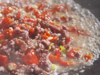 5、江西炒粉,放入50克小米椒碎和适量蒜末,炒出香味,加少许水继续翻炒;