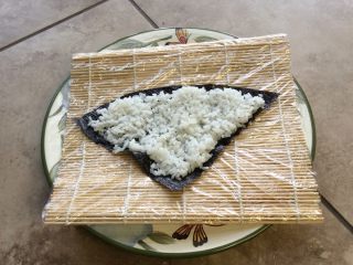 2、星星寿司,把紫菜剪成三角形。再将饭放到紫菜上，不要太厚，