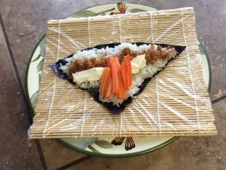 3、星星寿司,再把肉松，cheese cream，和胡萝卜放在寿司上。要把胡萝卜竖起放。这样裹起来更容易