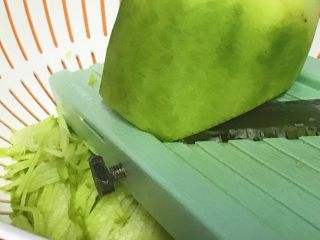 3、过年走油@萝卜丝丸子,用叉板把青萝卜叉成丝。