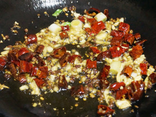 4、宫保鸡丁,锅内留少许底油,下姜米、蒜米、花椒粒、辣椒爆香锅