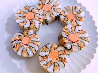 8、木鱼花香松花朵寿司,切的时候保鲜膜不要取掉，切成段就可以啦，然后切的时候和刚才一样，每切一刀，刀都要洗干净，沾凉白开水，忽略我渣渣的刀功。