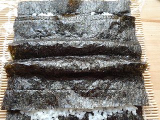 8、花朵寿司,将另一片紫菜包裹好凹字形。（大半片即可）。