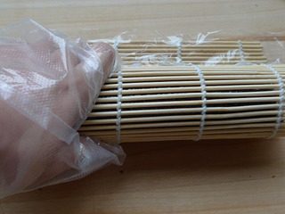 10、花朵寿司,用卷帘自下而上卷起来，注意边卷边揭掉保鲜膜。