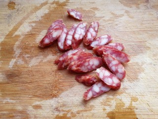 3、腊肠手撕包菜,将腊肠切斜片；