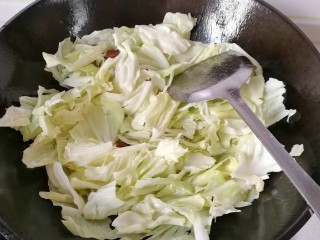 8、腊肠手撕包菜,再下入圆包菜翻炒；