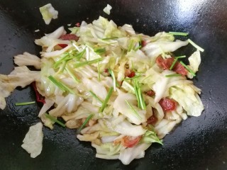 12、腊肠手撕包菜,最后洒葱段炒均匀起锅装盘；