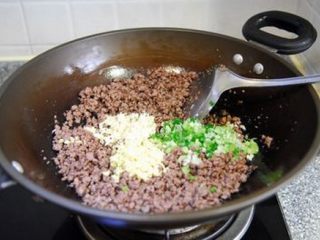 5、牛肉酱 ,炒至牛肉进一步收缩后加入葱姜蒜末继续翻炒