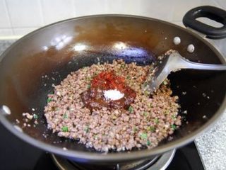 6、牛肉酱 ,待葱姜蒜末炒出香味后加入复合酱料和白糖继续翻炒