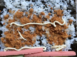 3、招牌寿司,铺上一层肉松，放好黄瓜和火腿肠，挤一点沙拉酱。