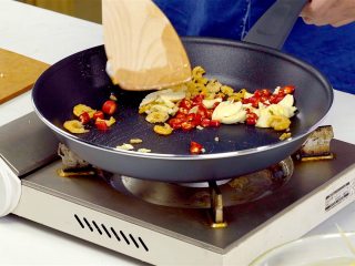 2、等戴一道菜之青木瓜沙拉,将泡发的海米擦干，炒锅放入猪油烧热，放入海米、大蒜、小米椒，炒出香气，盛出倒入石臼中