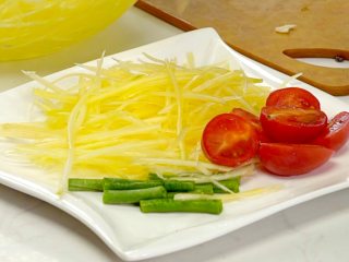 5、等戴一道菜之青木瓜沙拉,捞出青木瓜瓜丝，沥干装盘，搭配圣女果