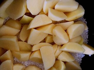 5、土豆鸡块焖饭,浸泡过的米去水，倒入电饭煲中，加少许水，刚刚没过大米的水量就可以了，先把土豆块挑出铺在大米上，这样土豆会更加入味。