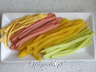 2、翻转樱花寿司,把鸡蛋饼切丝、火腿肠条、黄瓜条和大根条放盘里（黄瓜皮若是老，就把皮削了）。