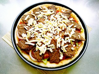 21、秘制烤牛肉披萨,将剩下的马苏里拉奶酪全撒在牛肉上